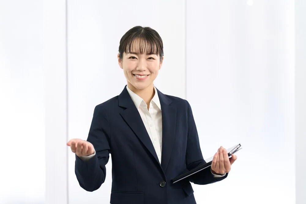 タブレットを持ち説明する紺色のスーツ姿の営業担当者