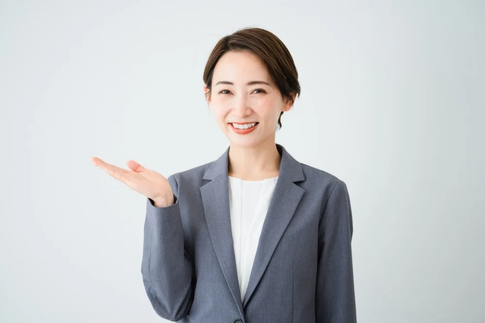 手のひらを広げ案内する女性