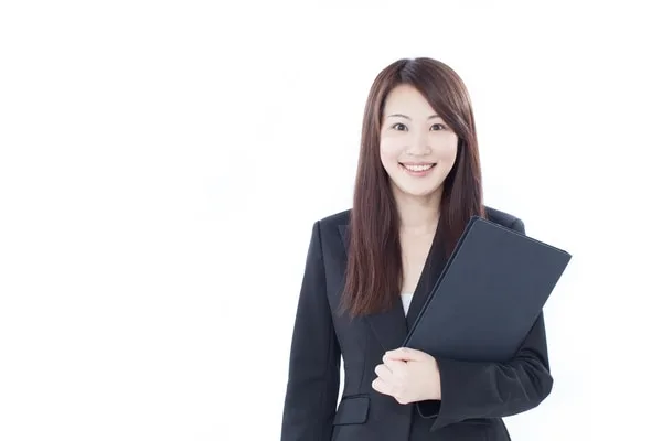 ビジネススーツを着た女性が書類を持って微笑んでいる