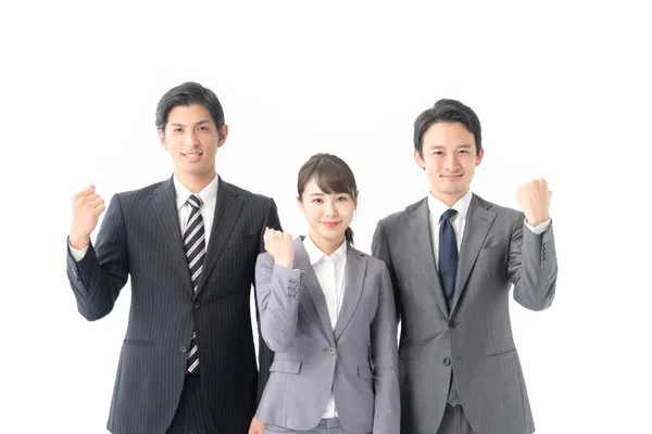 ビジネススーツの営業担当者3人がガッツポーズで笑顔