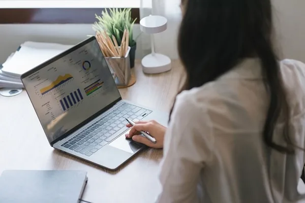 ノートパソコンで営業データを分析する女性