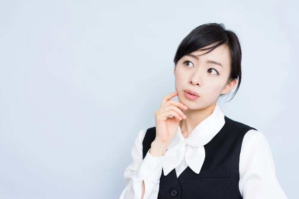 考え込む表情の営業職の女性