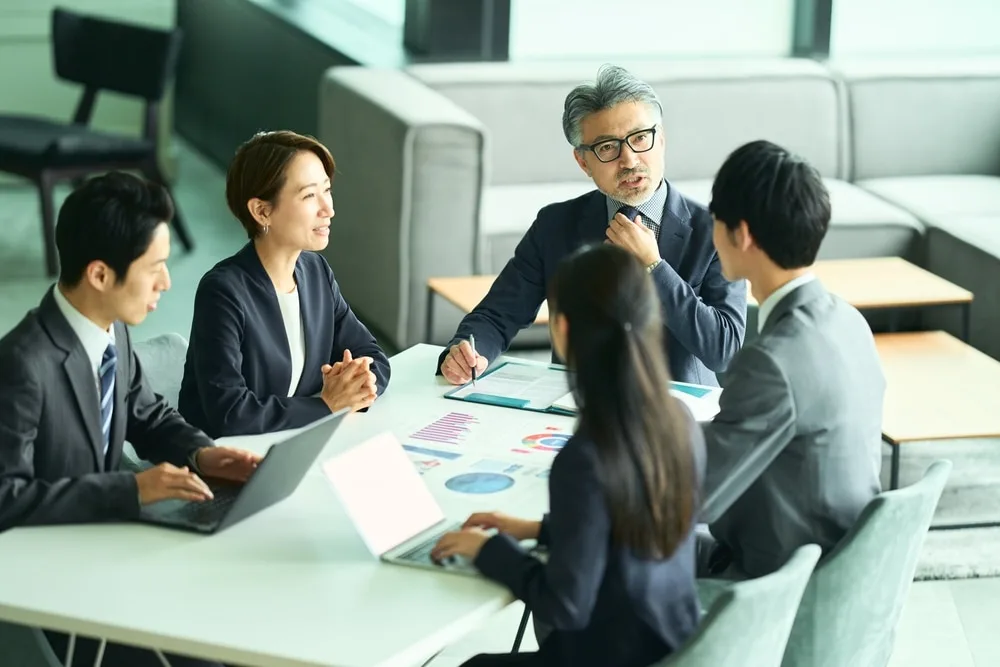 ビジネスチームが資料を前に会議を開催