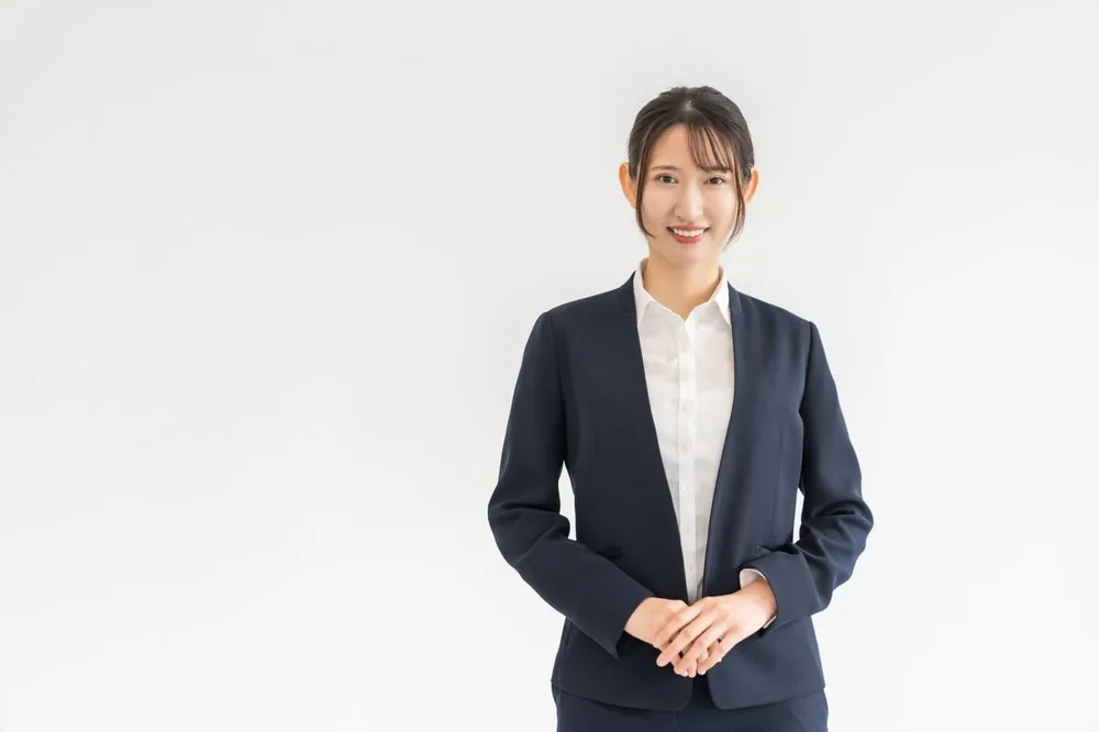 紺色のジャケットを着た女性営業職員が微笑んでいる