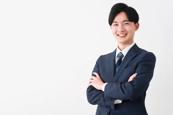 腕を組んで笑顔で立つビジネスマン