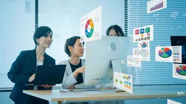 ビジネスパーソンが営業データと分析チャートで戦略を検討