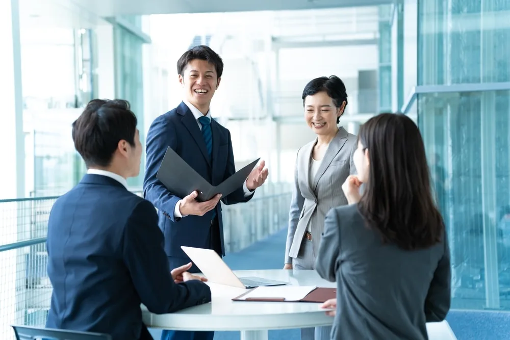 ファイルを手に打ち合わせする男女4人