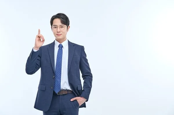 人差し指を立てる眼鏡の男性ビジネスパーソン