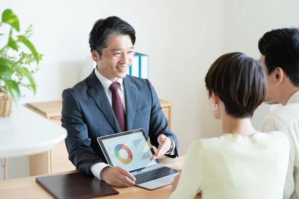 営業担当者がノートパソコンの円グラフ画面を顧客に説明