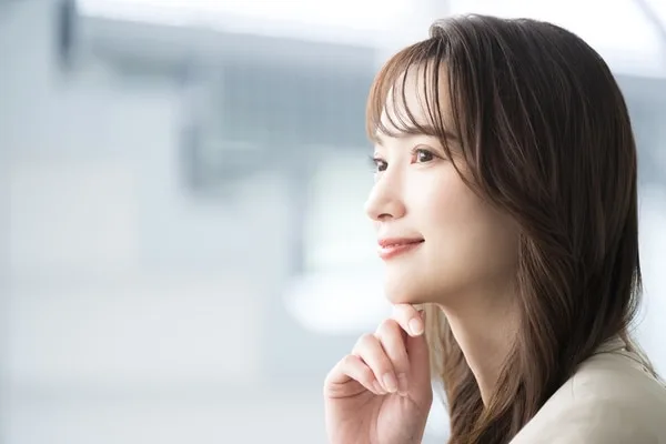 手を顎に添え考える表情の女性