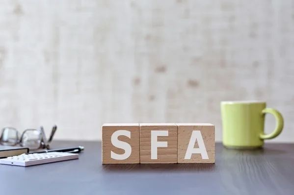 SFAと書かれた木製ブロックがデスクに置かれている