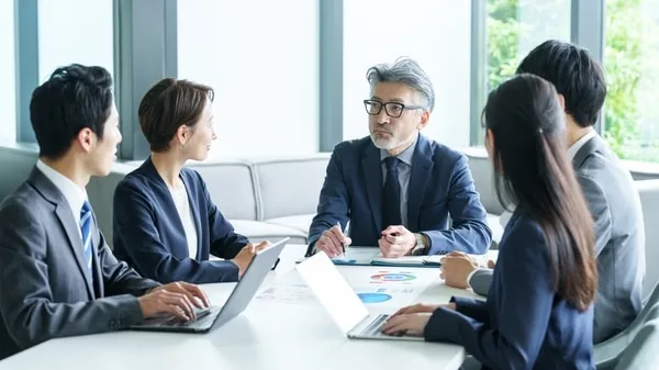 営業チームがテーブルを囲んで会議をしている様子