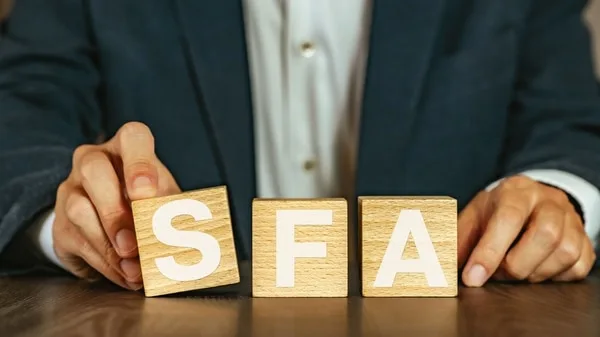 ビジネスマンがSFAと書かれた木製ブロックを手で並べている