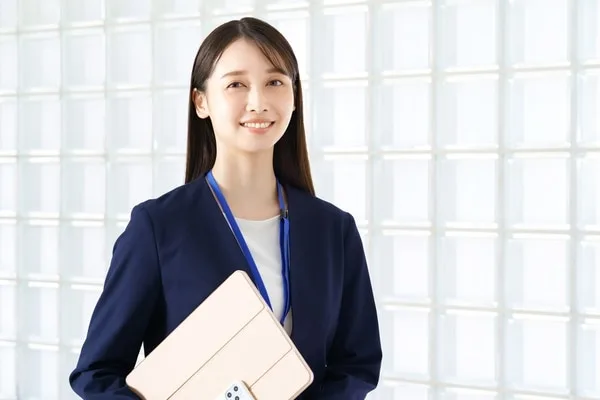 タブレットを抱えた紺スーツの女性