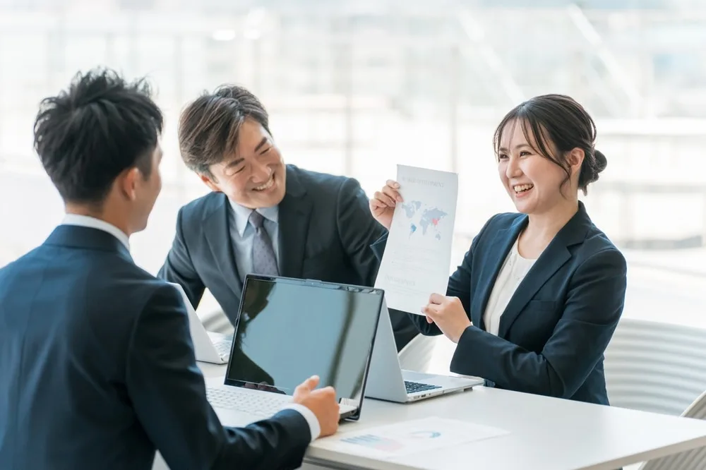 ビジネス資料を見ながら打ち合わせする営業チーム
