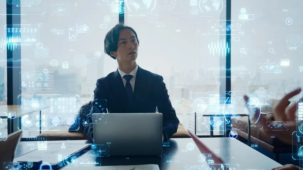 ビジネスマンがノートパソコンで営業データを分析する様子