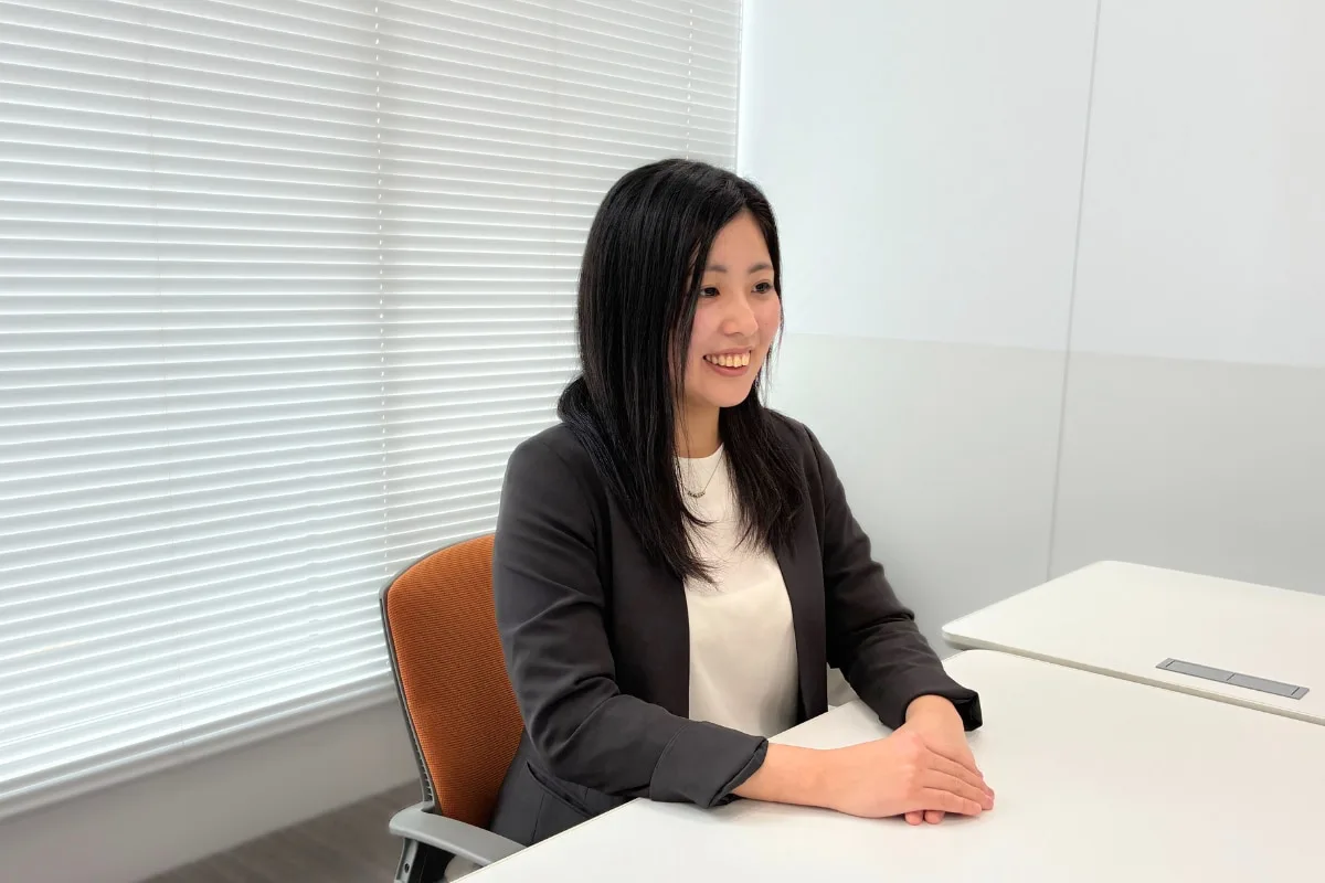 オフィスの机で笑顔で対話する営業担当者