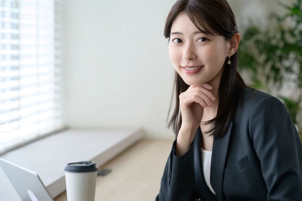オフィスのデスクで顧客管理システムについて考える営業担当者