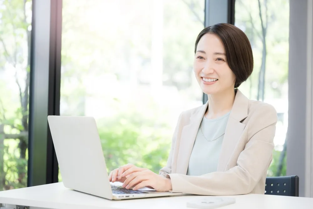 ノートパソコンで作業する女性ビジネスパーソン