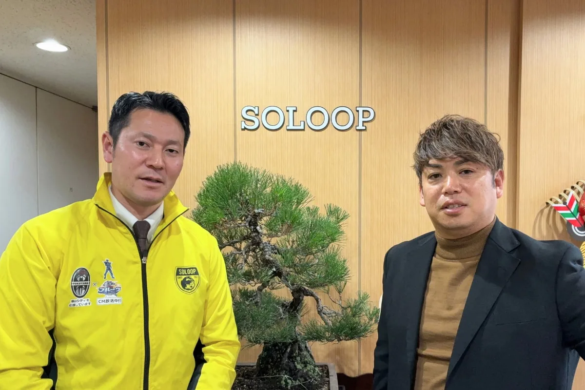 木製背景の前に立つ複数人と盆栽、SOLOOPロゴ