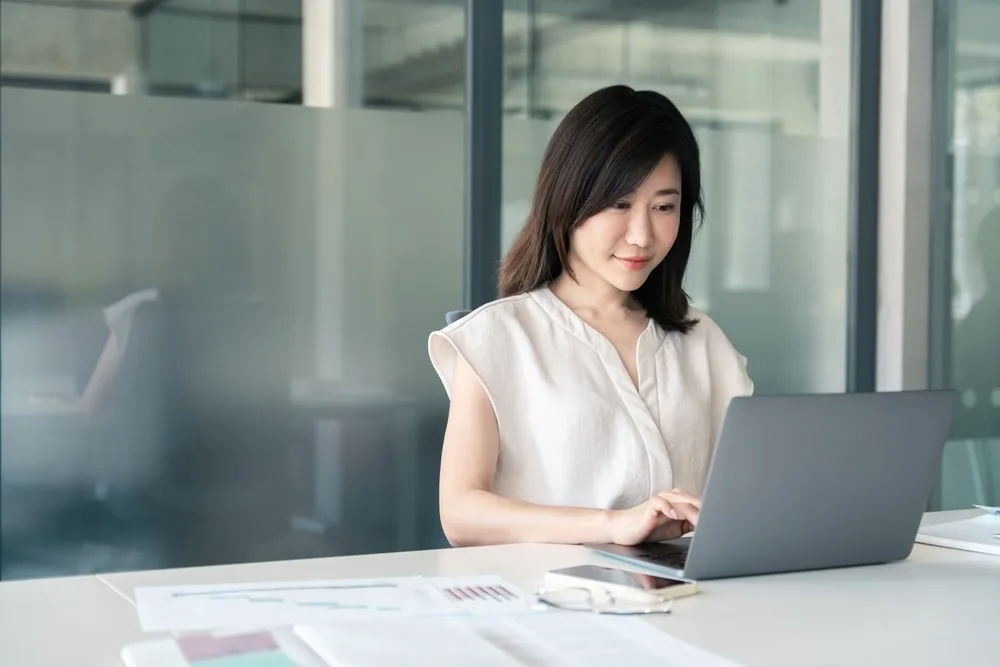 オフィスでノートパソコンを操作する女性営業担当者