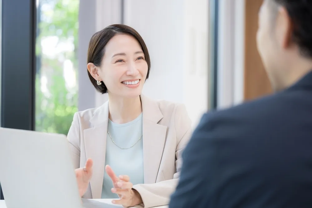 ビジネスウーマンがノートパソコンを前に相手と話し合っている様子