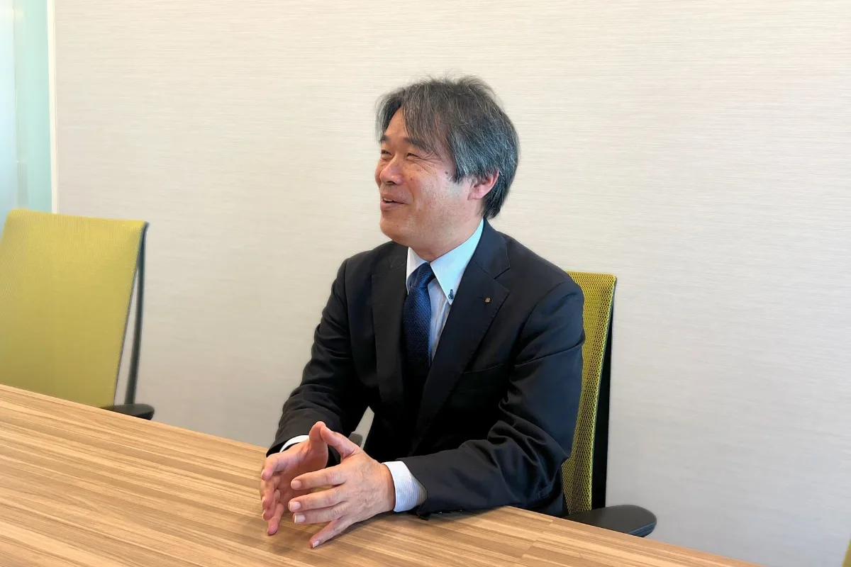 ビジネススーツ姿の男性がテーブルに向かい席に座る