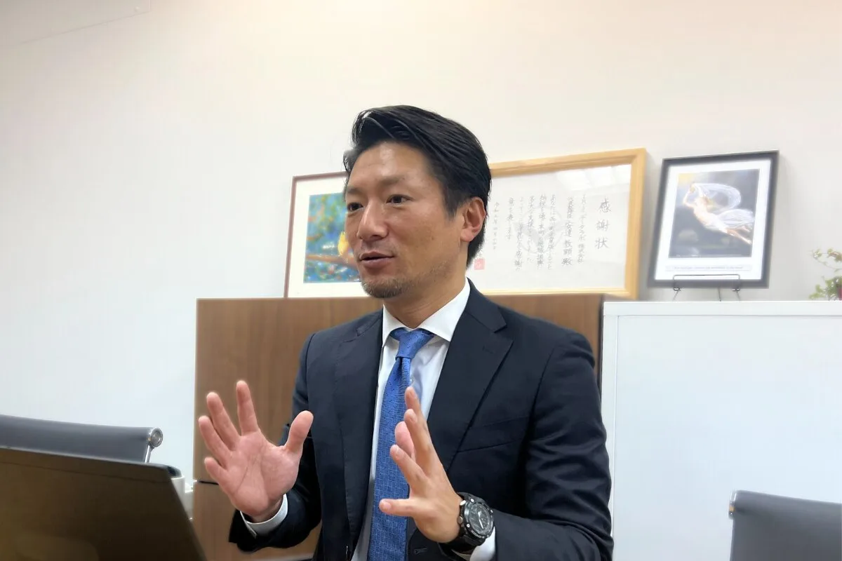 ビジネススーツ姿の男性がジェスチャーしながら説明する様子