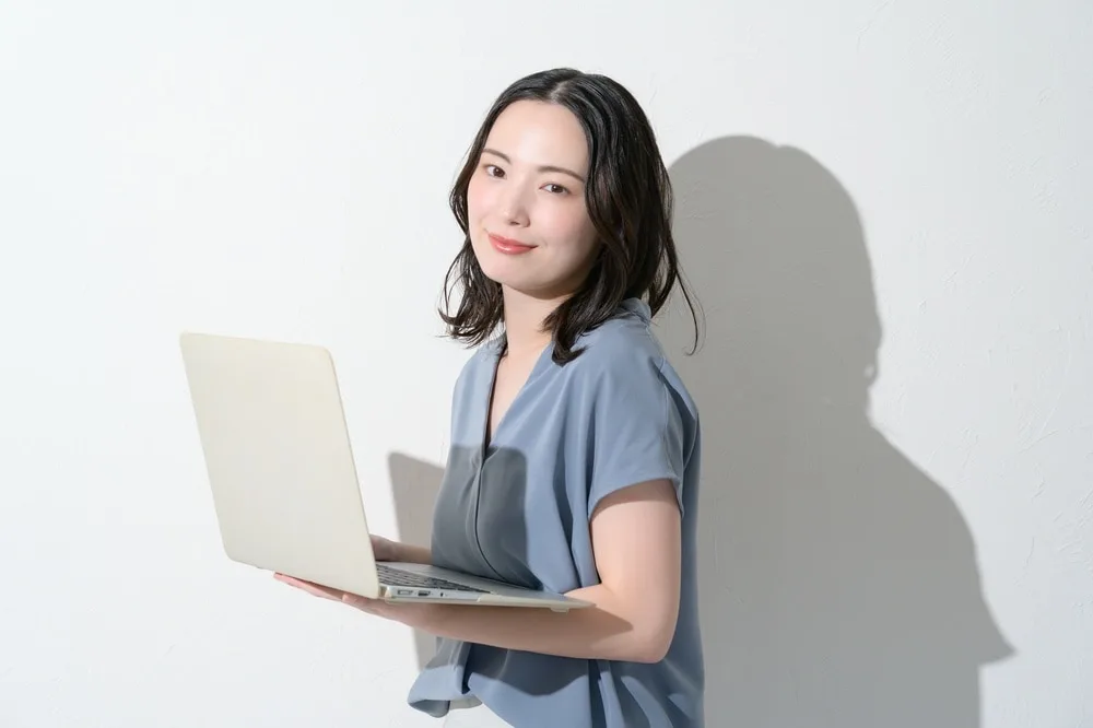 ノートパソコンを操作する女性営業スタッフ