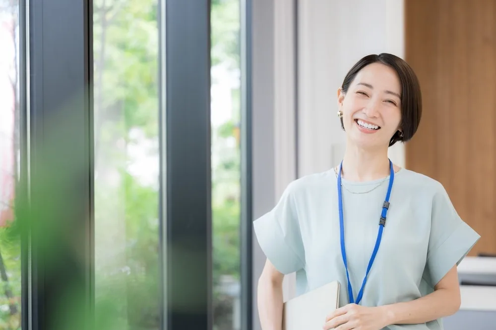 タブレットを持つ女性が微笑んでいる